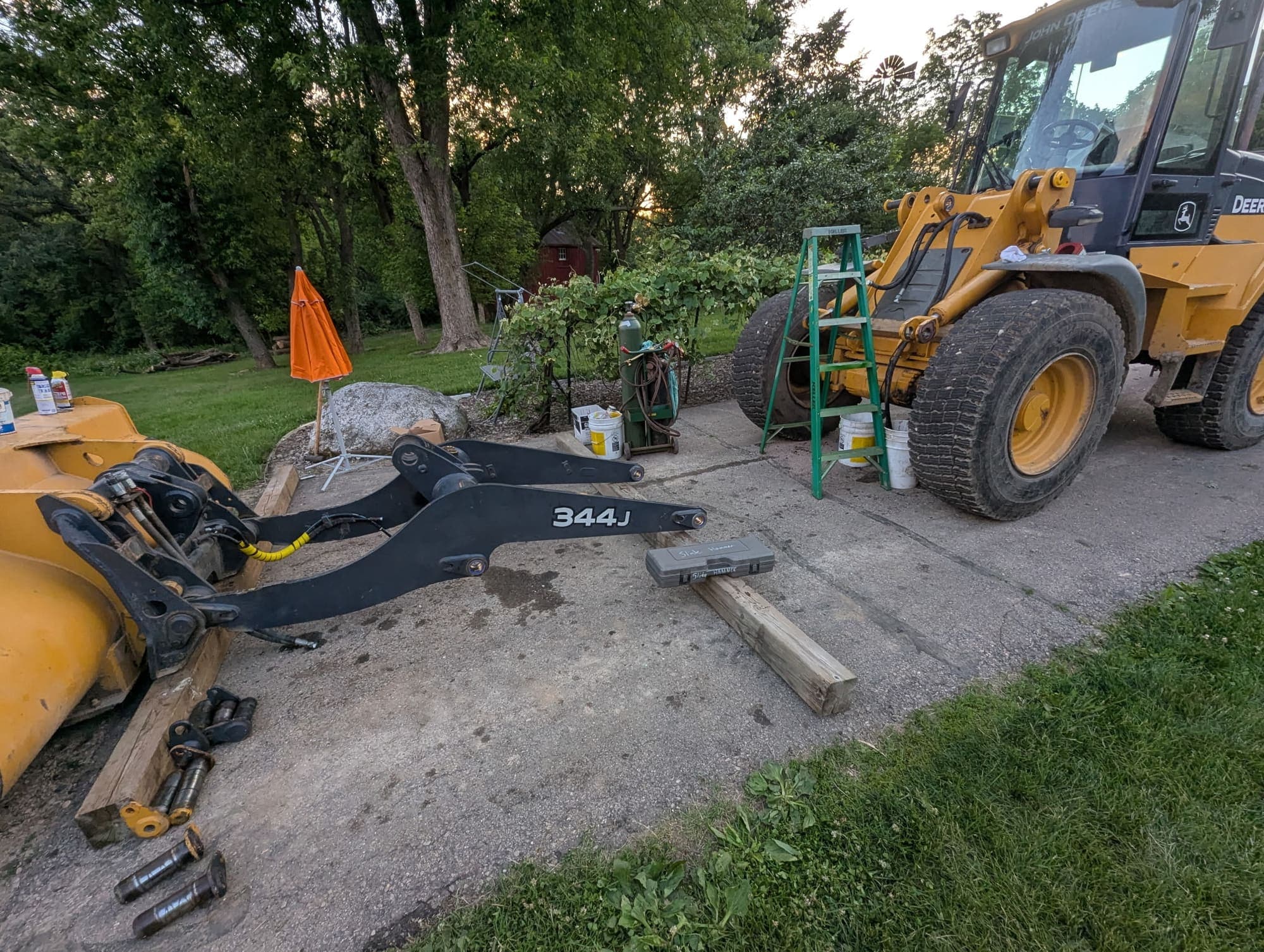 John Deere wheel loader at the customer's place with its boom arms off for pin repairs
